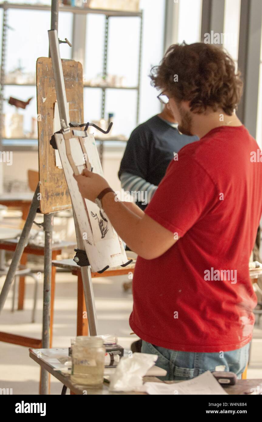 Profile shot of an artist, working at an easel in a studio at the Mattin Center, at the Johns Hopkins University, Baltimore, Maryland, February 6, 2006. From the Homewood Photography Collection. () Stock Photo
