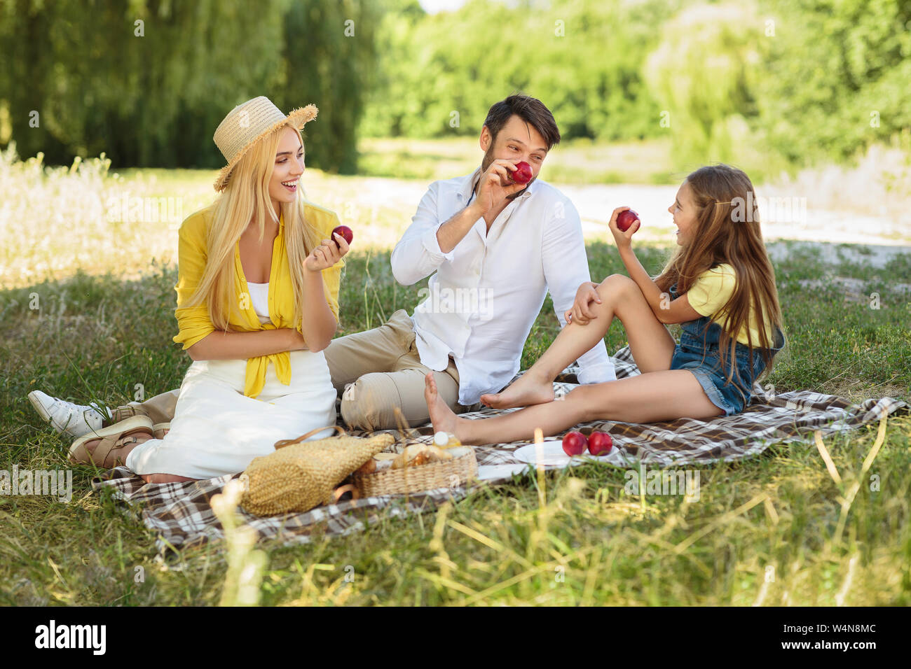 Happy family having picnic and eating apples in park Stock Photo - Alamy