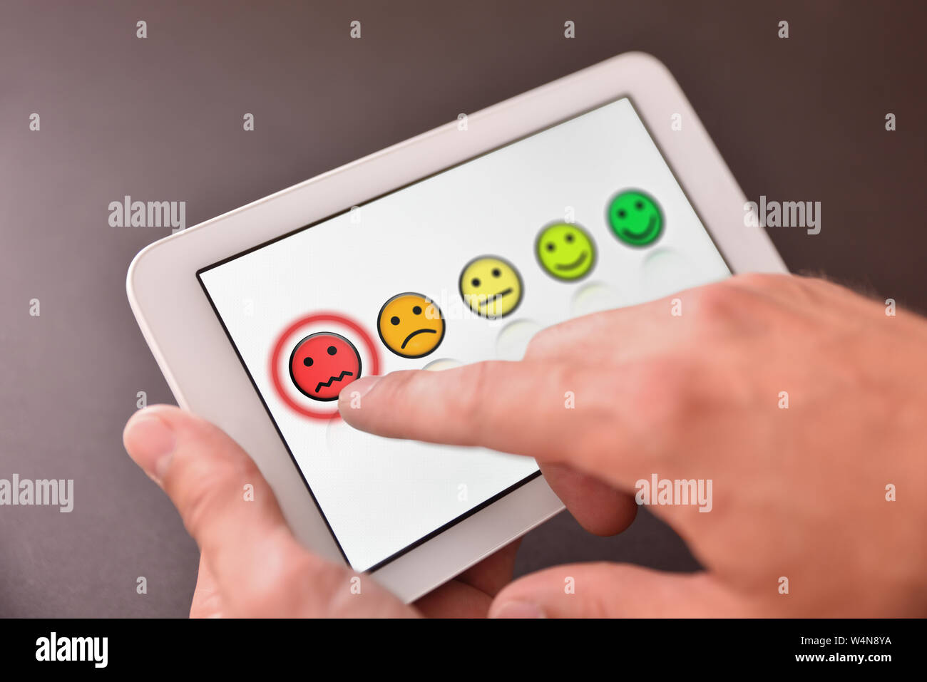 Registering a negative opinion on an electronic device. Horizontal composition. Elevated view. Stock Photo