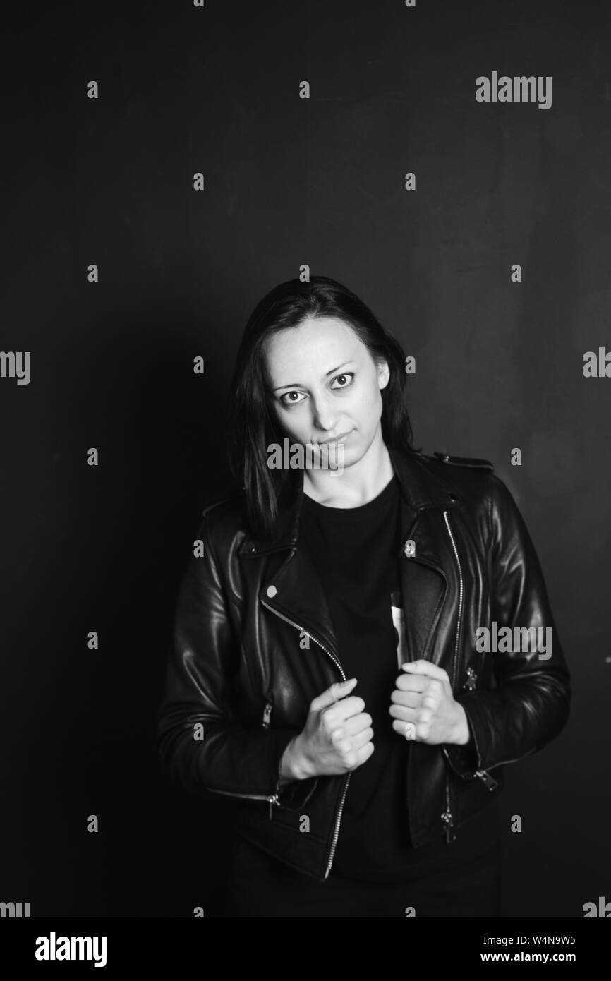 Studio portrait of an attractive young woman in a black leather jacket ...