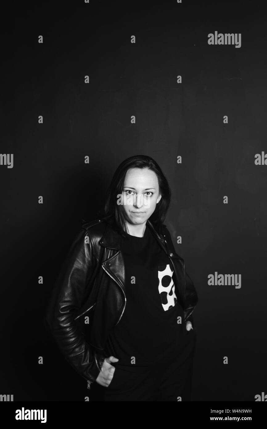 Studio portrait of an attractive young woman in a black leather jacket ...