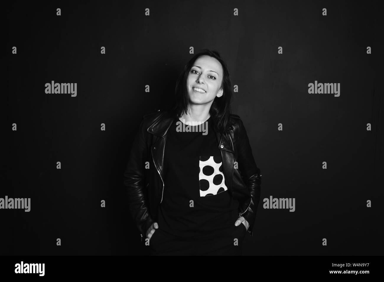 Studio portrait of an attractive young woman in a black leather jacket ...