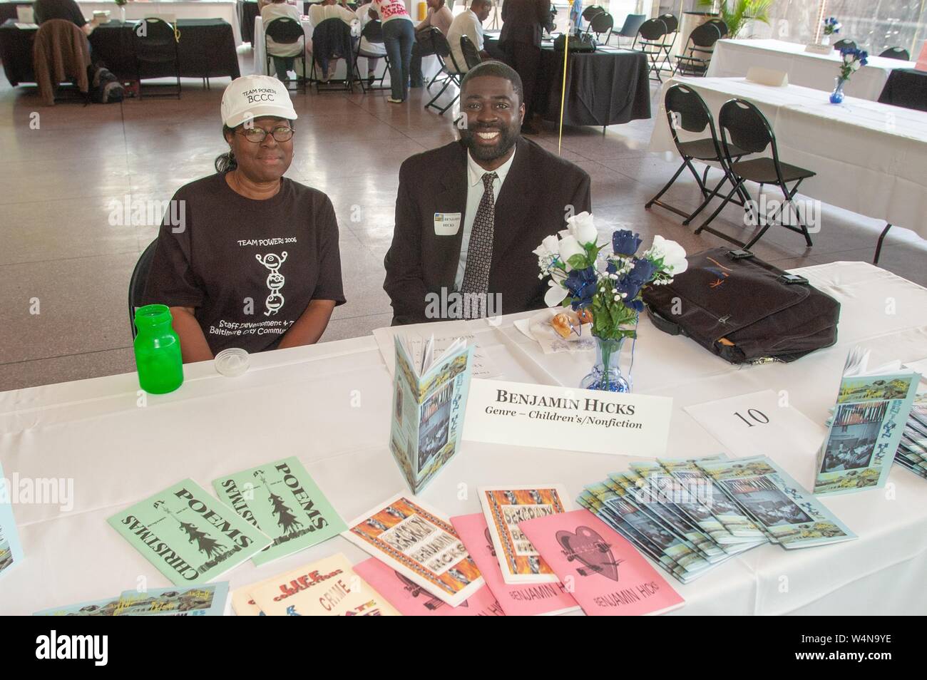 Children's non-fiction author Benjamin Hicks, sits with a colleague at a table displaying his publications, during an African-American Book Festival at the Johns Hopkins University, Baltimore, Maryland, May 6, 2006. From the Homewood Photography Collection. () Stock Photo