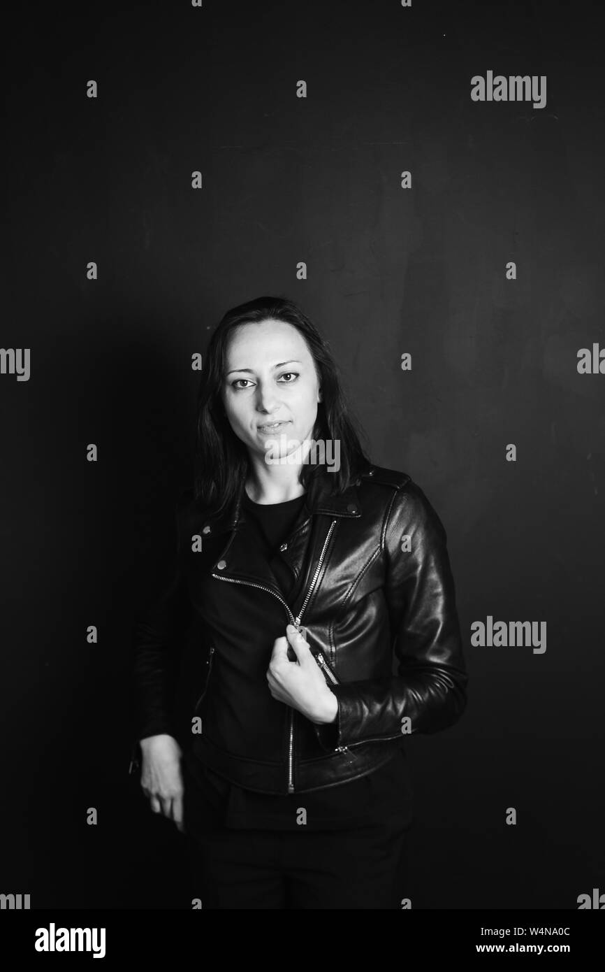 Studio portrait of an attractive young woman in a black leather jacket ...