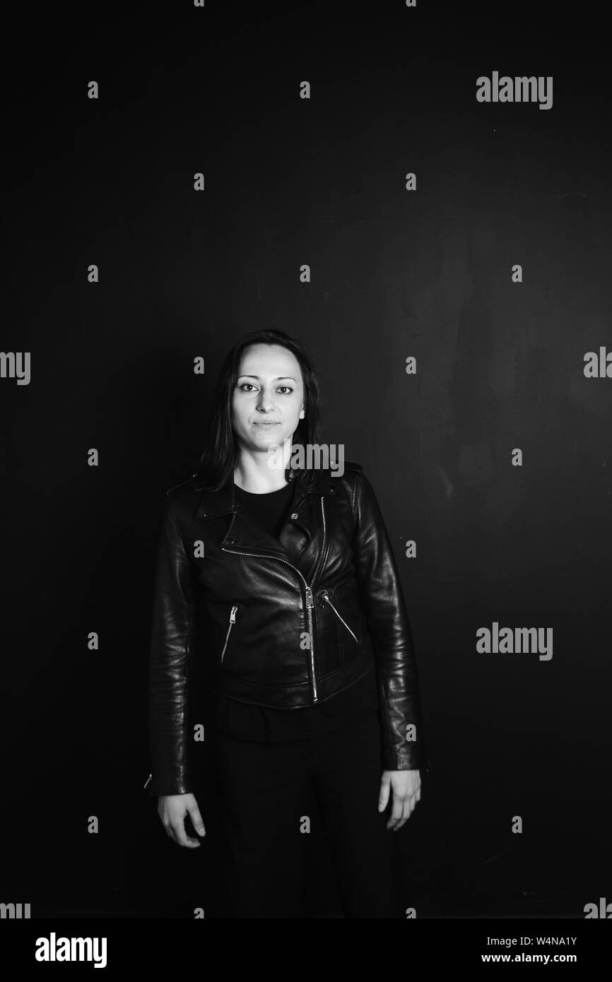 Studio portrait of an attractive young woman in a black leather jacket ...