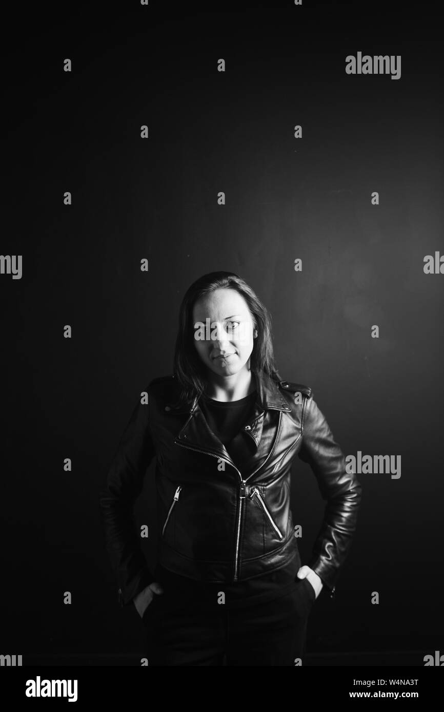 Studio portrait of an attractive young woman in a black leather jacket ...