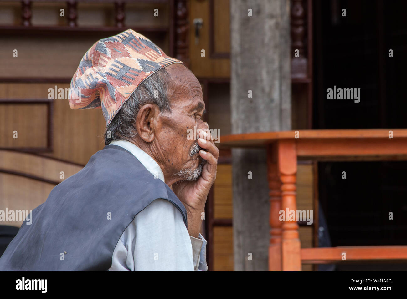 Elderly Nepalese man in thought with his hand to his mouth Stock Photo