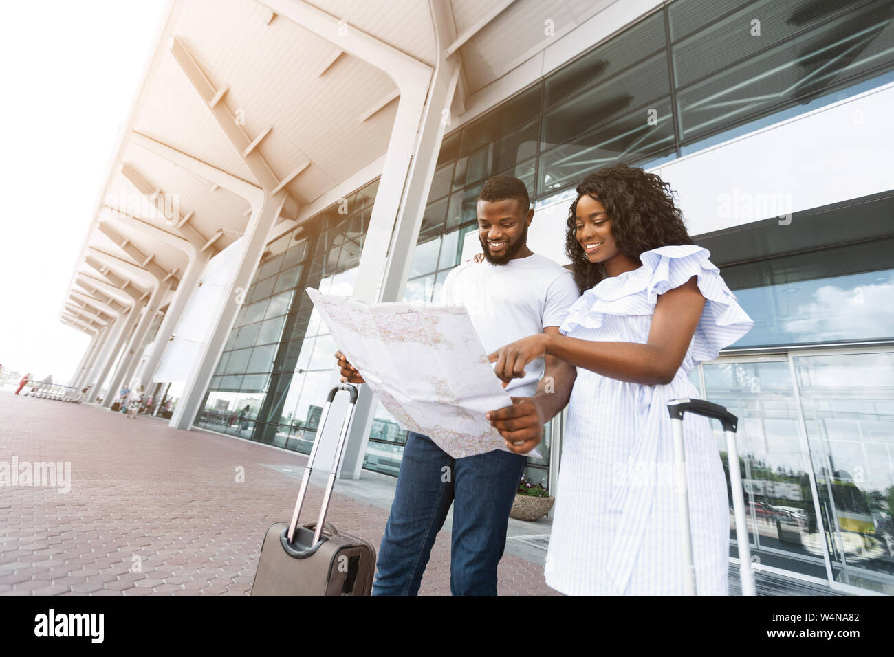 Young black couple looking at map at airport terminal building Stock ...