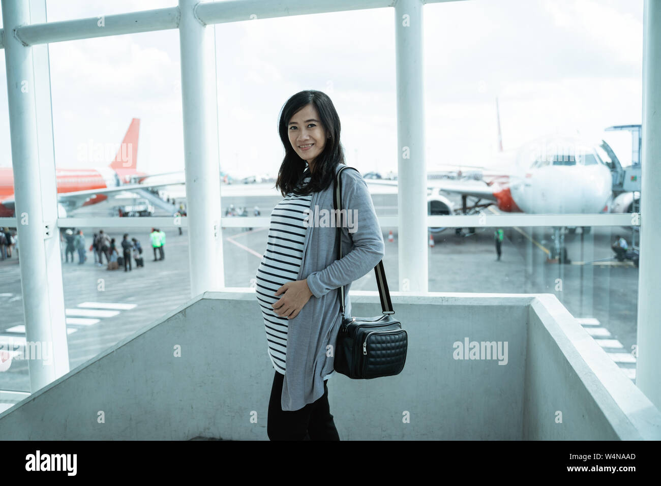a pregnant mother stands holding her stomach Stock Photo - Alamy