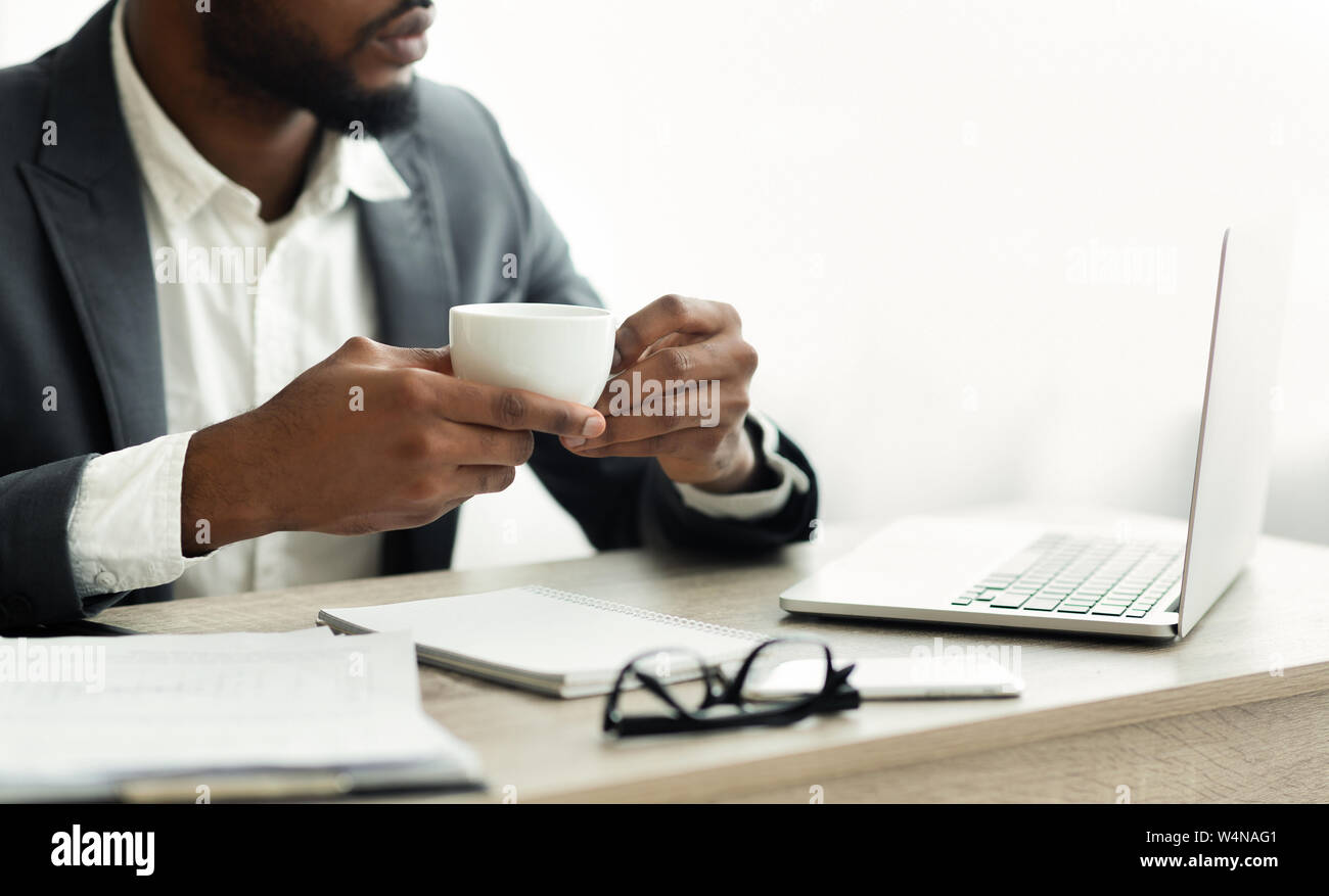 Serious african american businessman drinking coffee in modern office having a break. Free space Stock Photo