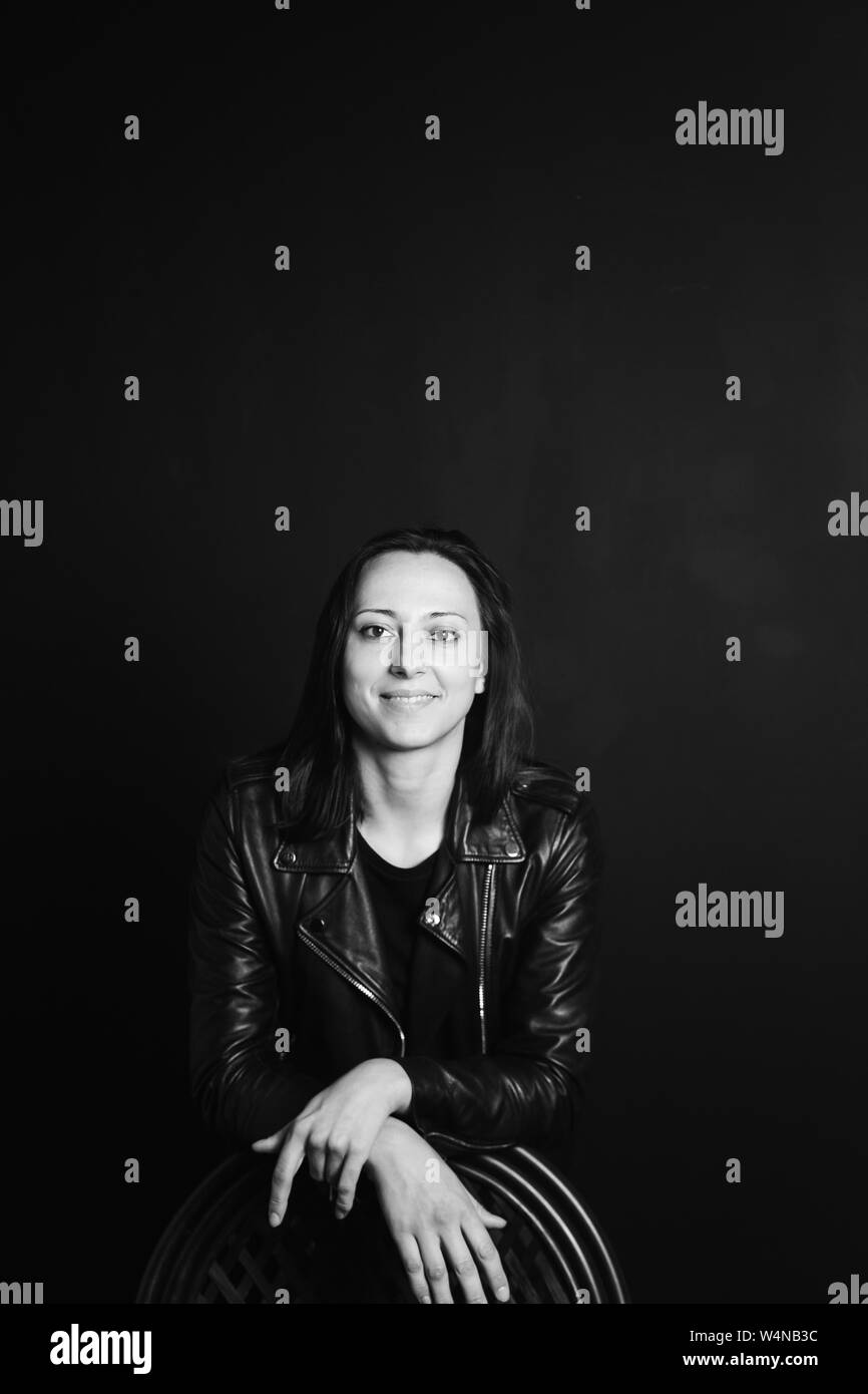 Studio portrait of an attractive young woman in a black leather jacket ...
