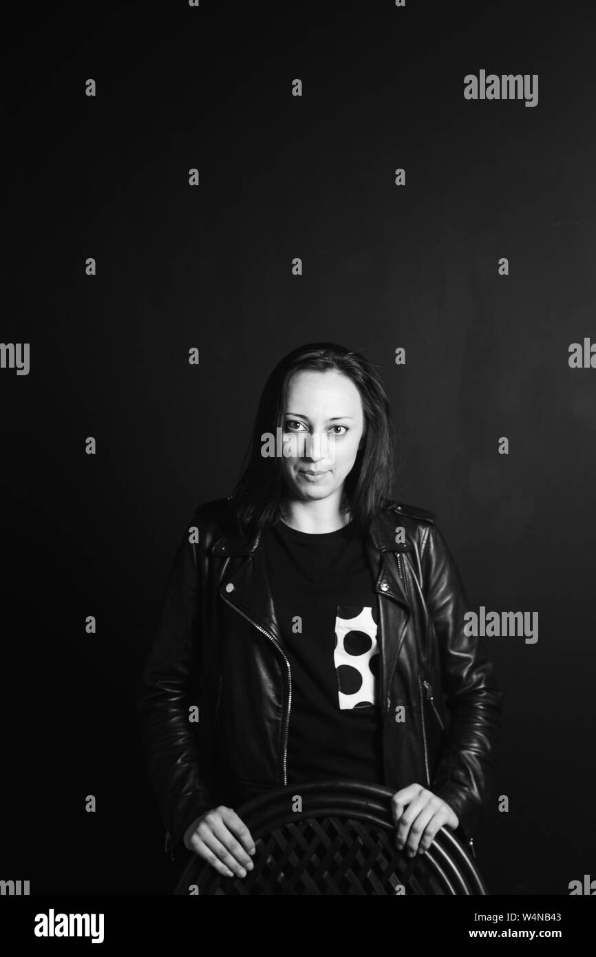 Studio portrait of an attractive young woman in a black leather jacket ...