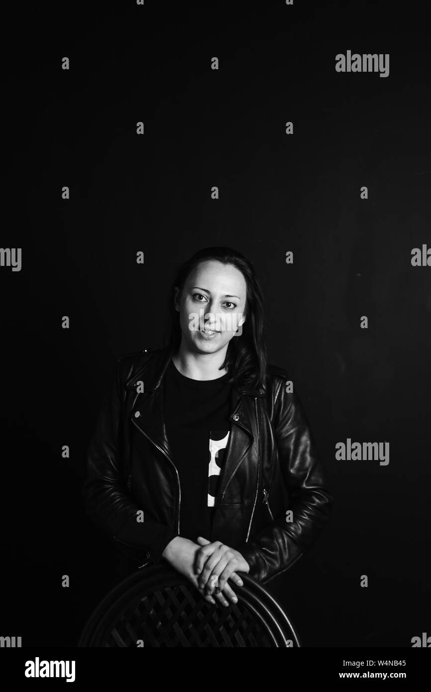 Studio portrait of an attractive young woman in a black leather jacket ...
