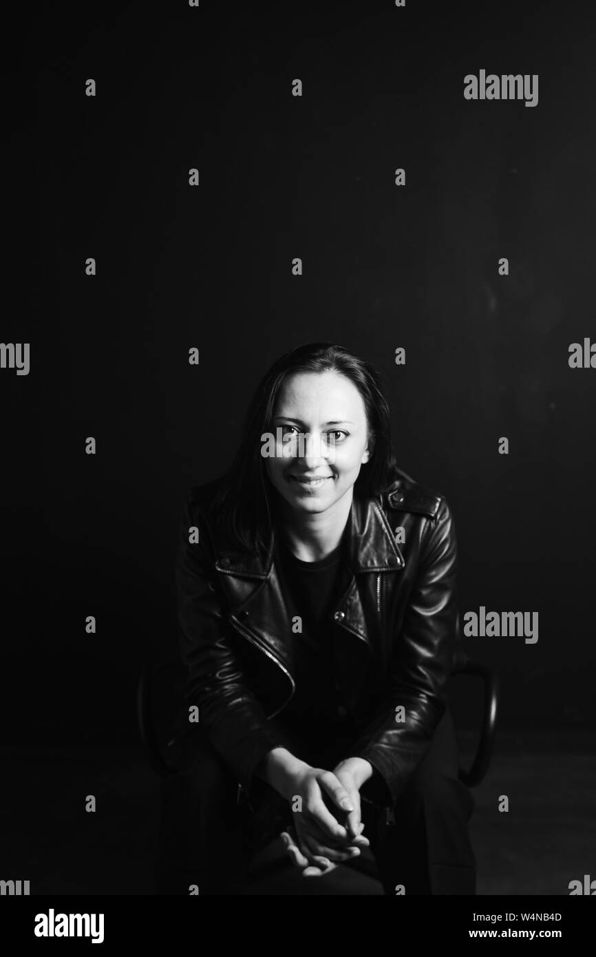 Studio portrait of an attractive young woman in a black leather jacket ...