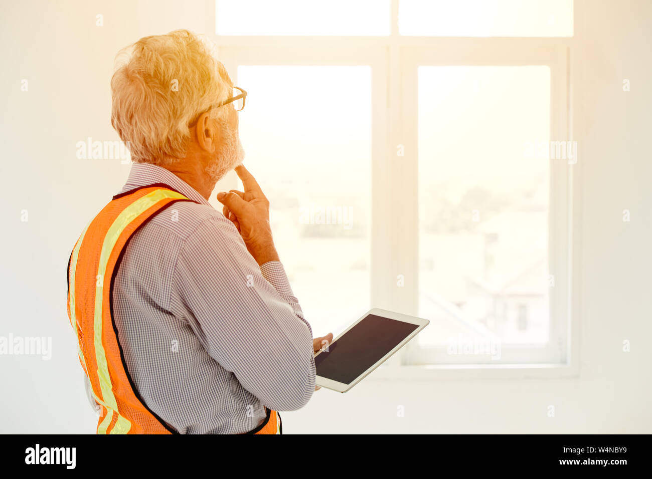 senior engineer thinking project looking at windows handle tablet for future development concept Stock Photo