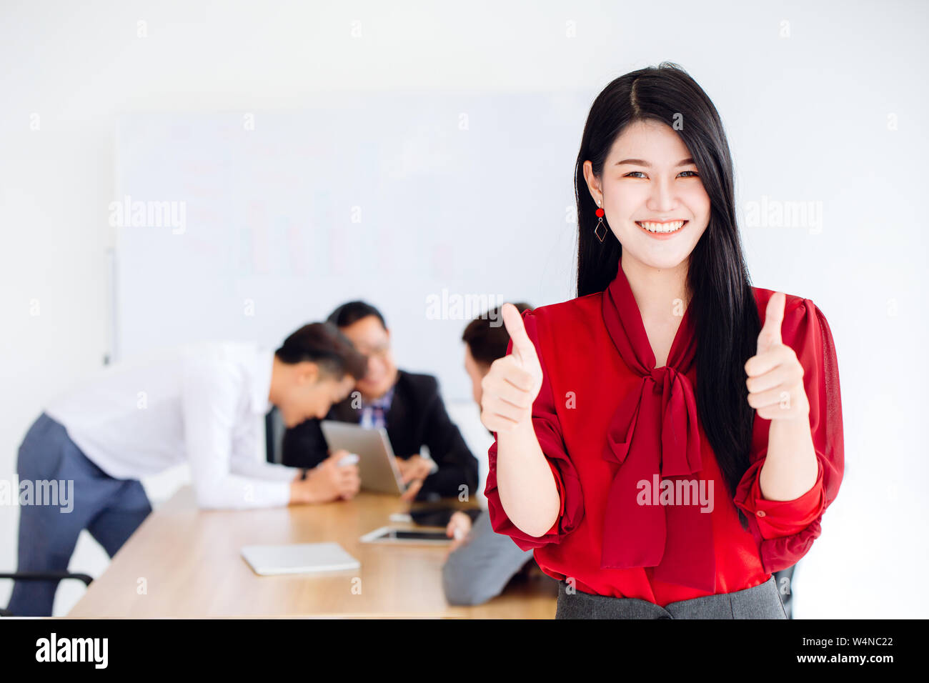 Asian business girl ceo show two hand thumb up good working together in office concept Stock Photo