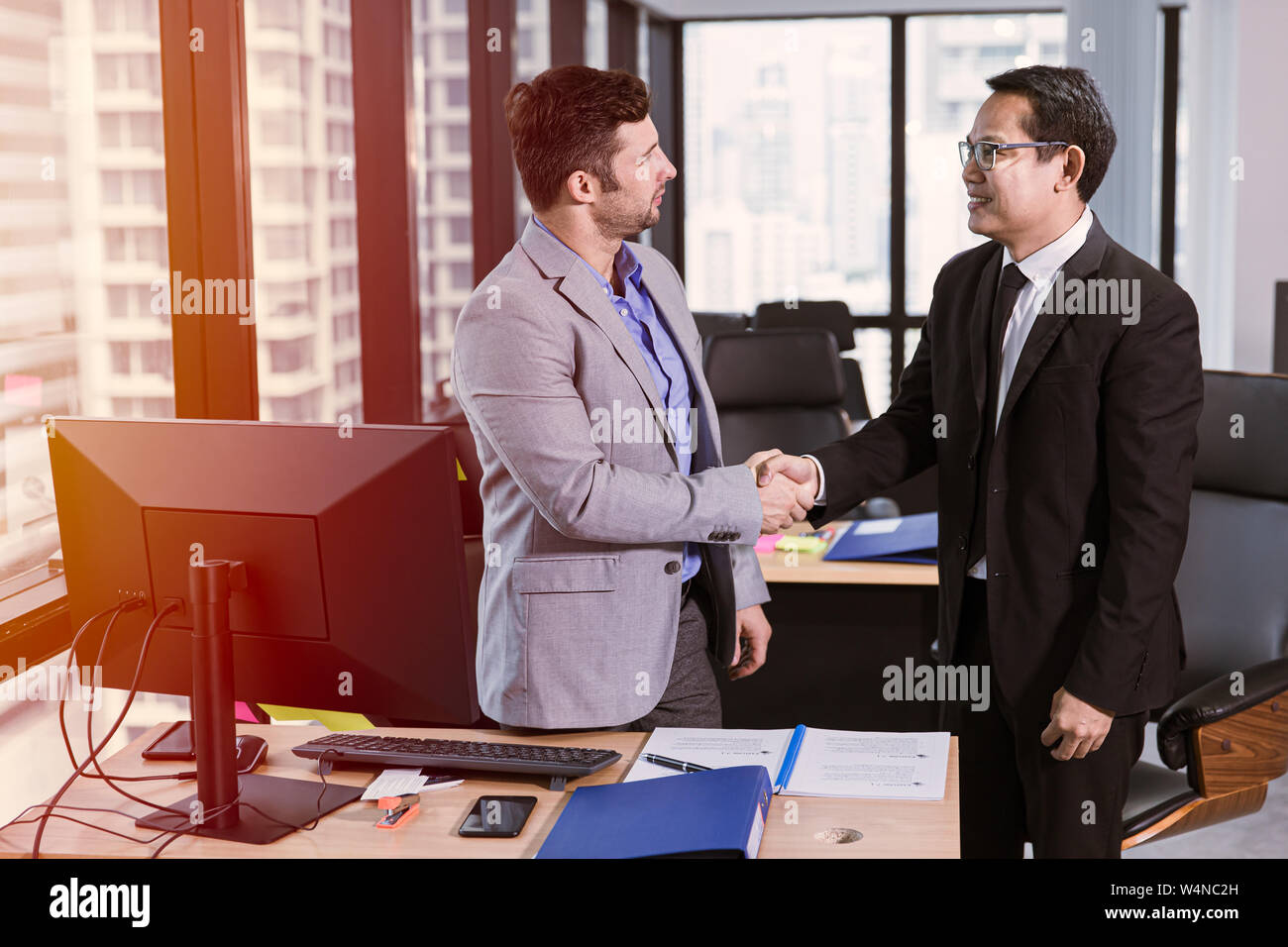 businessman mix race meet smiling and shake hands together in the office Stock Photo