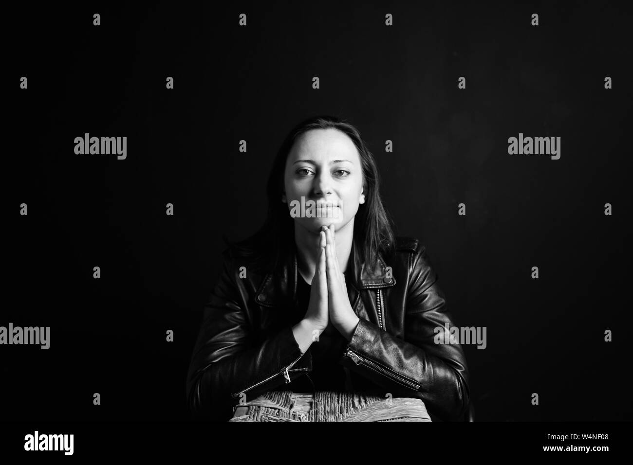 Studio portrait of an attractive young woman in a black leather jacket against a plain background Stock Photo