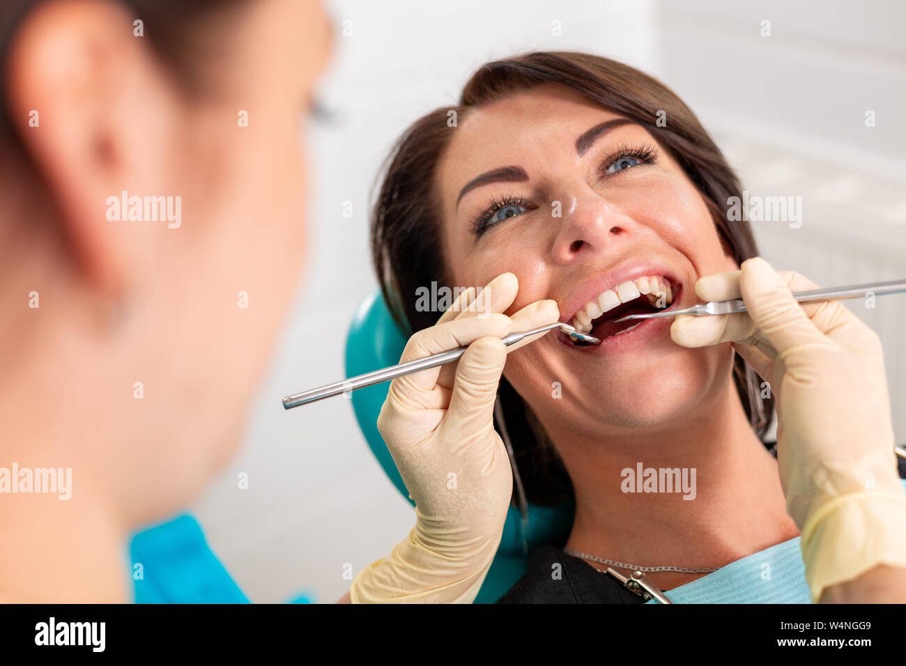 Putting dental braces to the woman's teeth at the dental office