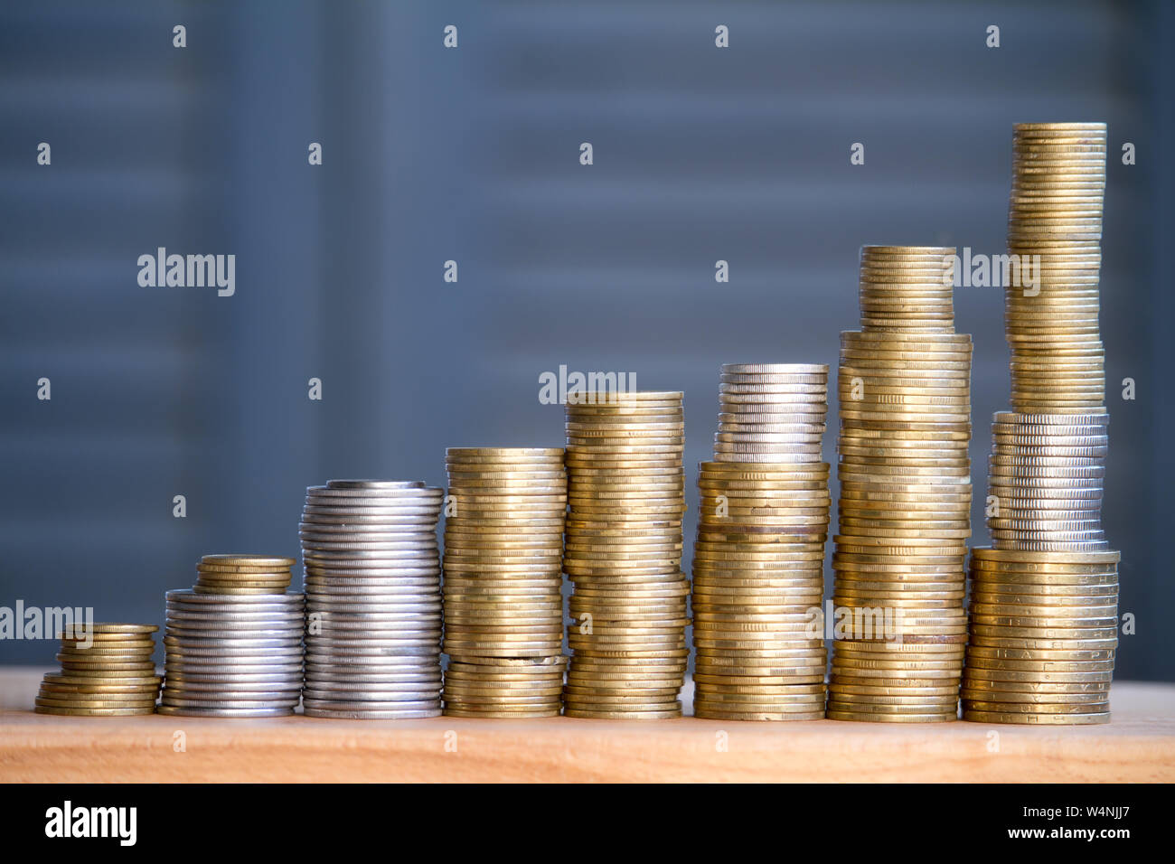 Closeup of columns of multi-colored coins of increasing height, the concept of saving and saving money, selective focus Stock Photo