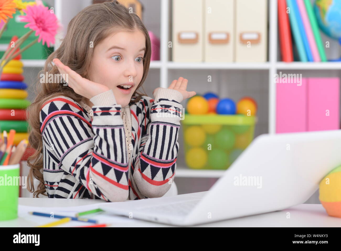 Emotional teen girl using laptop at her room Stock Photo - Alamy