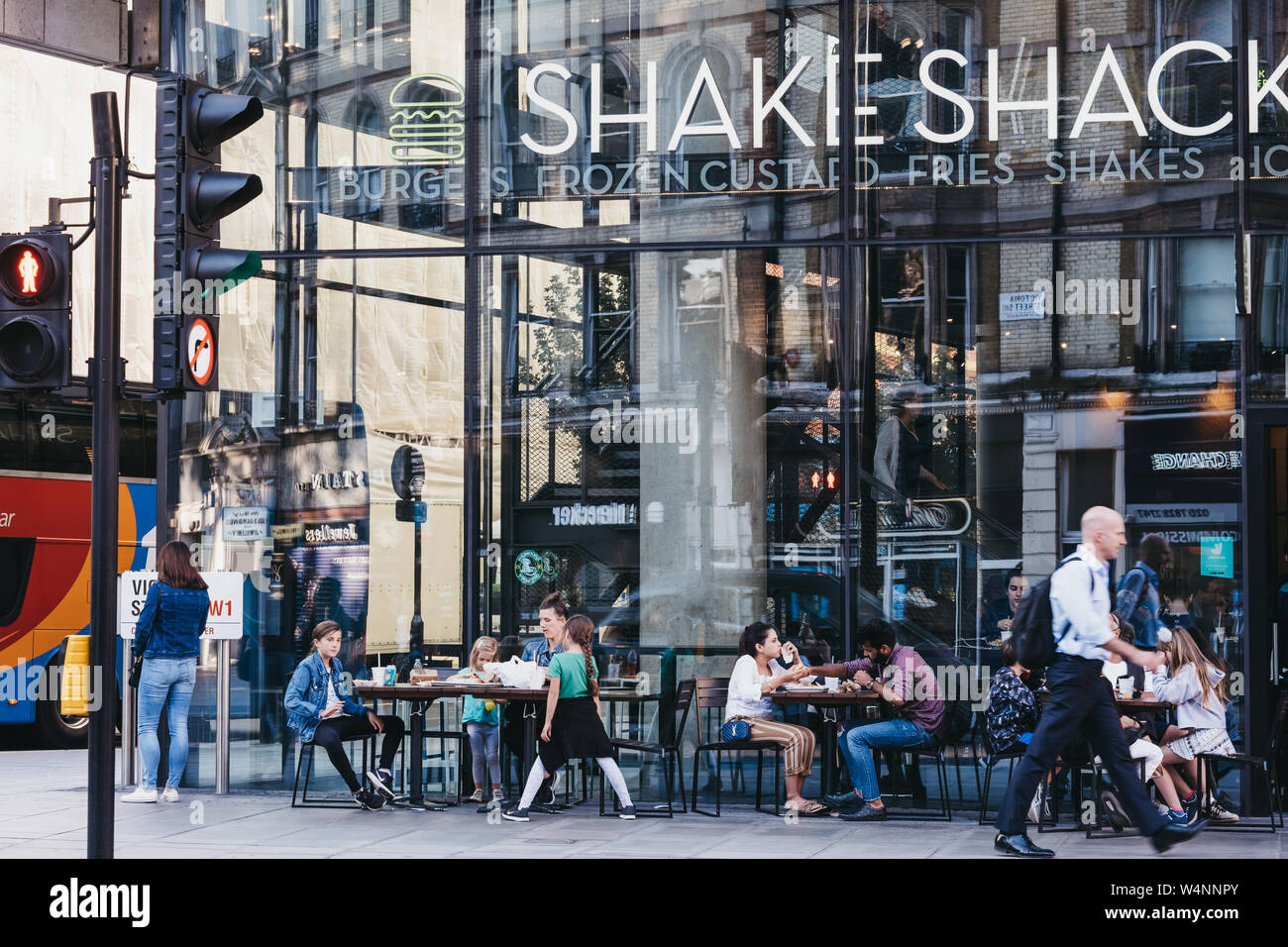 London, UK - July 15, 2019: People sitting at the outdoor tables of Shake Shack in Victoria station. Shake Shack is an American fast food restaurant c Stock Photo