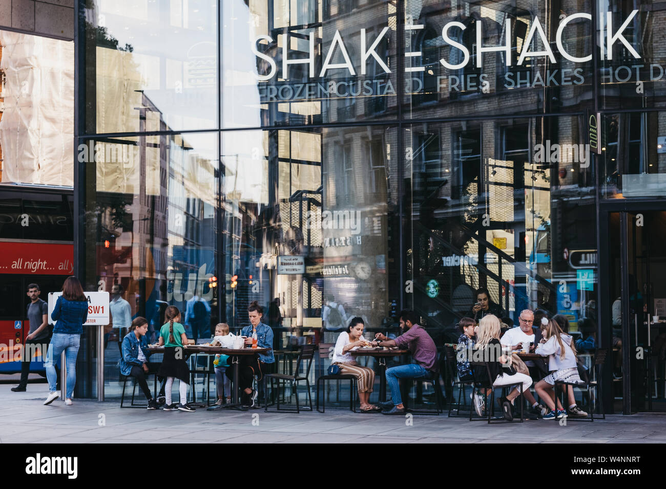 London, UK - July 15, 2019: People sitting at the outdoor tables of Shake Shack in Victoria station. Shake Shack is an American fast food restaurant c Stock Photo