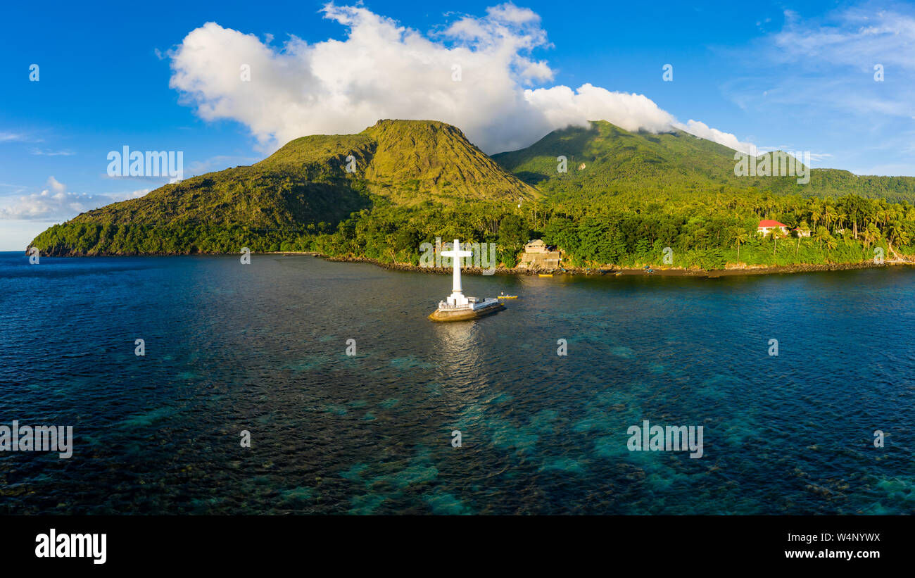 Aerial drone view of a large cross marking a sunken cemetery with