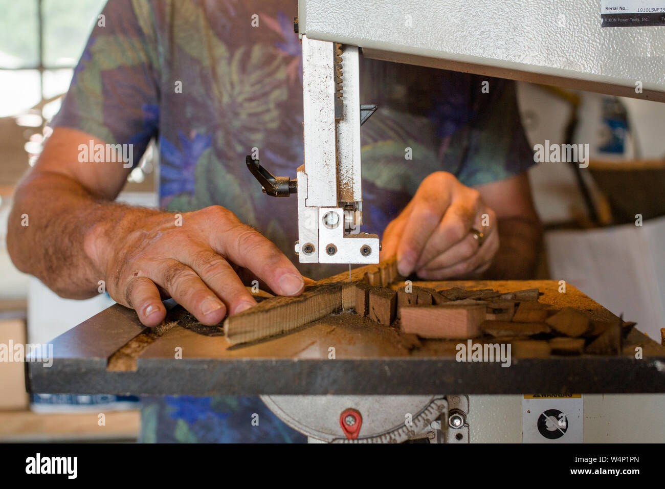 Close-up view of man crafting wood art on band saw Stock Photo