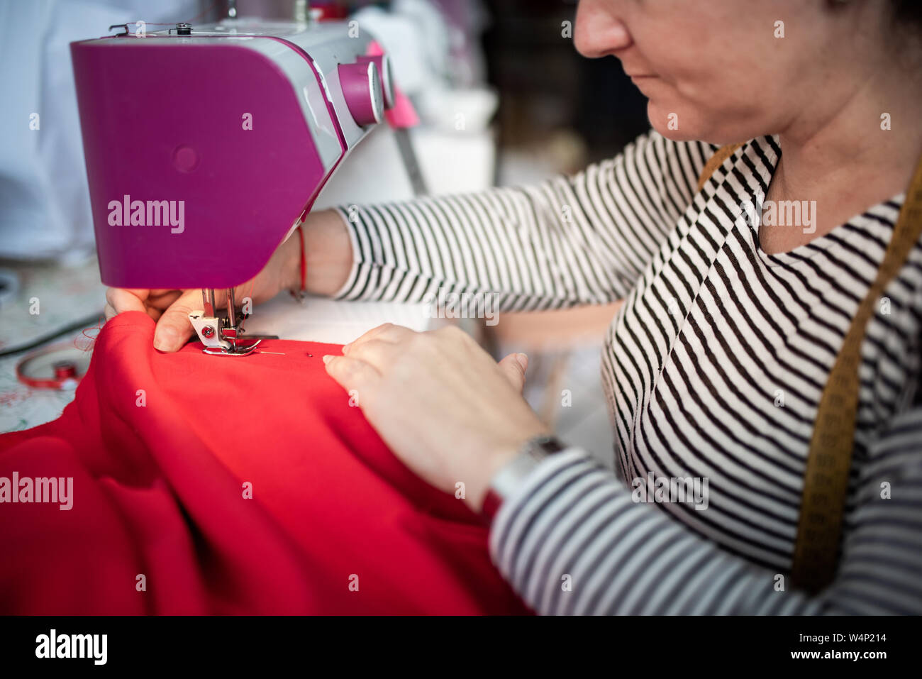 https://c8.alamy.com/comp/W4P214/closeup-of-adult-woman-seamstress-sews-clothes-and-put-thread-in-needl-W4P214.jpg