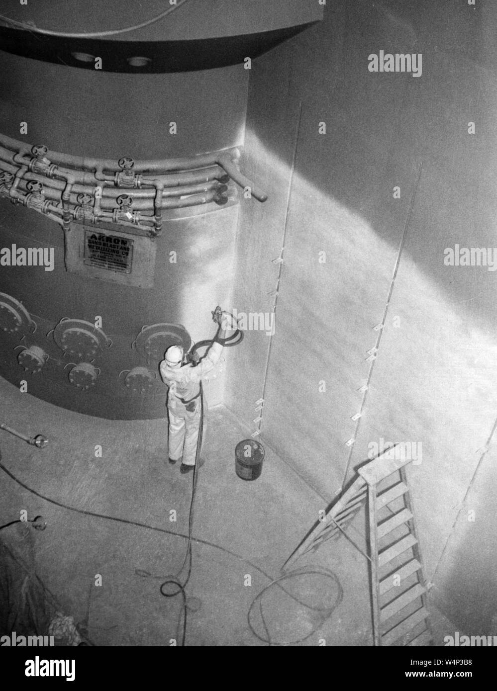 Worker spray paints one of the quadrant walls and a shielding wall surrounding the reactor pressure tank at the Plum Brook Station, John H. Glenn Research Center at Lewis Field, Cleveland, Ohio, 2003. Image courtesy National Aeronautics and Space Administration (NASA). () Stock Photo