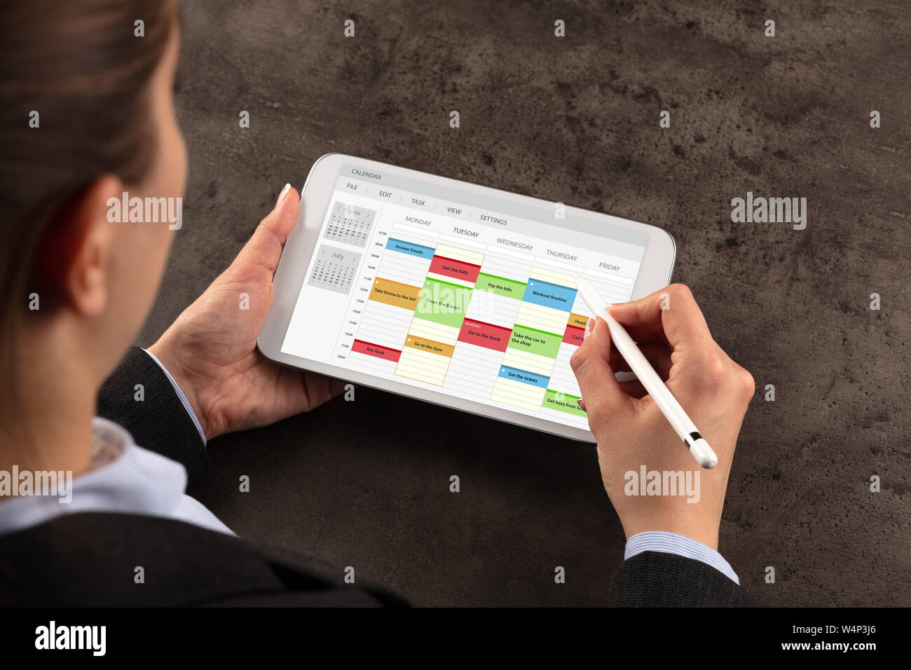 Business woman schedule her weekly program on tablet Stock Photo