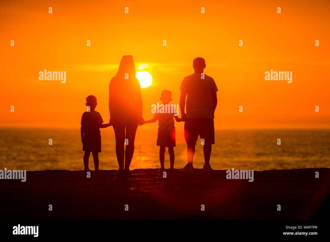 Perfect family watching the sunset over the sea Stock Photo