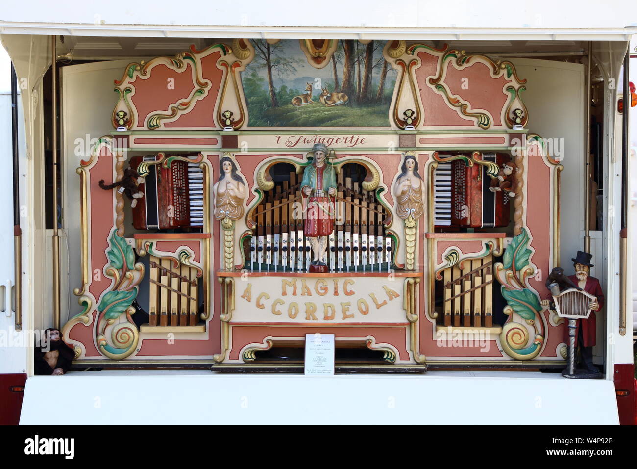 Pink faced Street or Barrel Organ, with pipes showing, a music instrument, this unmanned auto player of  repetitous music,a magic accordeola tunes Stock Photo