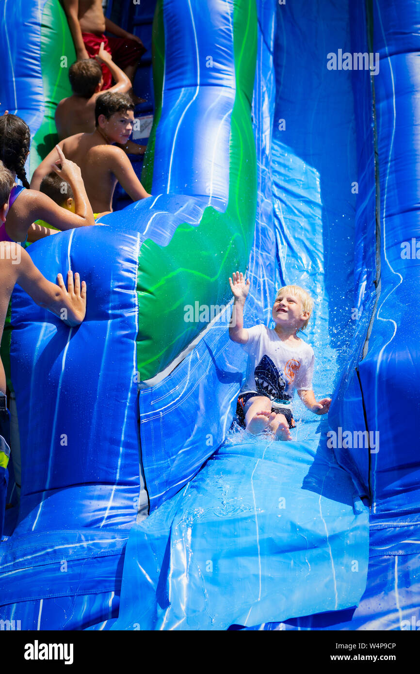 The look on the face says it all as kids come down the waterslide to cool off on a hot summer day in Alabama. Stock Photo
