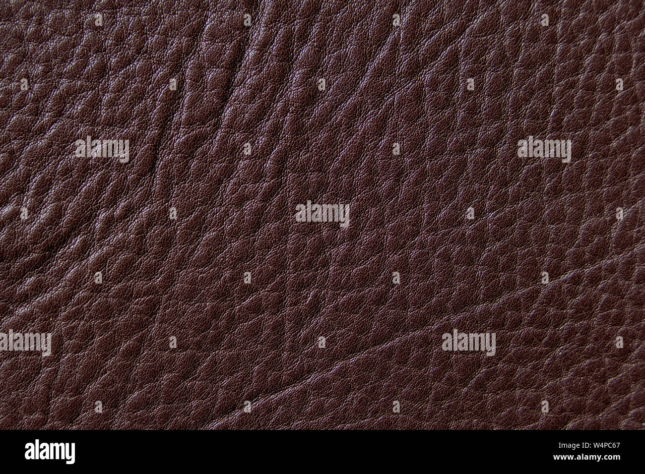 Brown genuine leather texture background with wrinkles. Closeup of