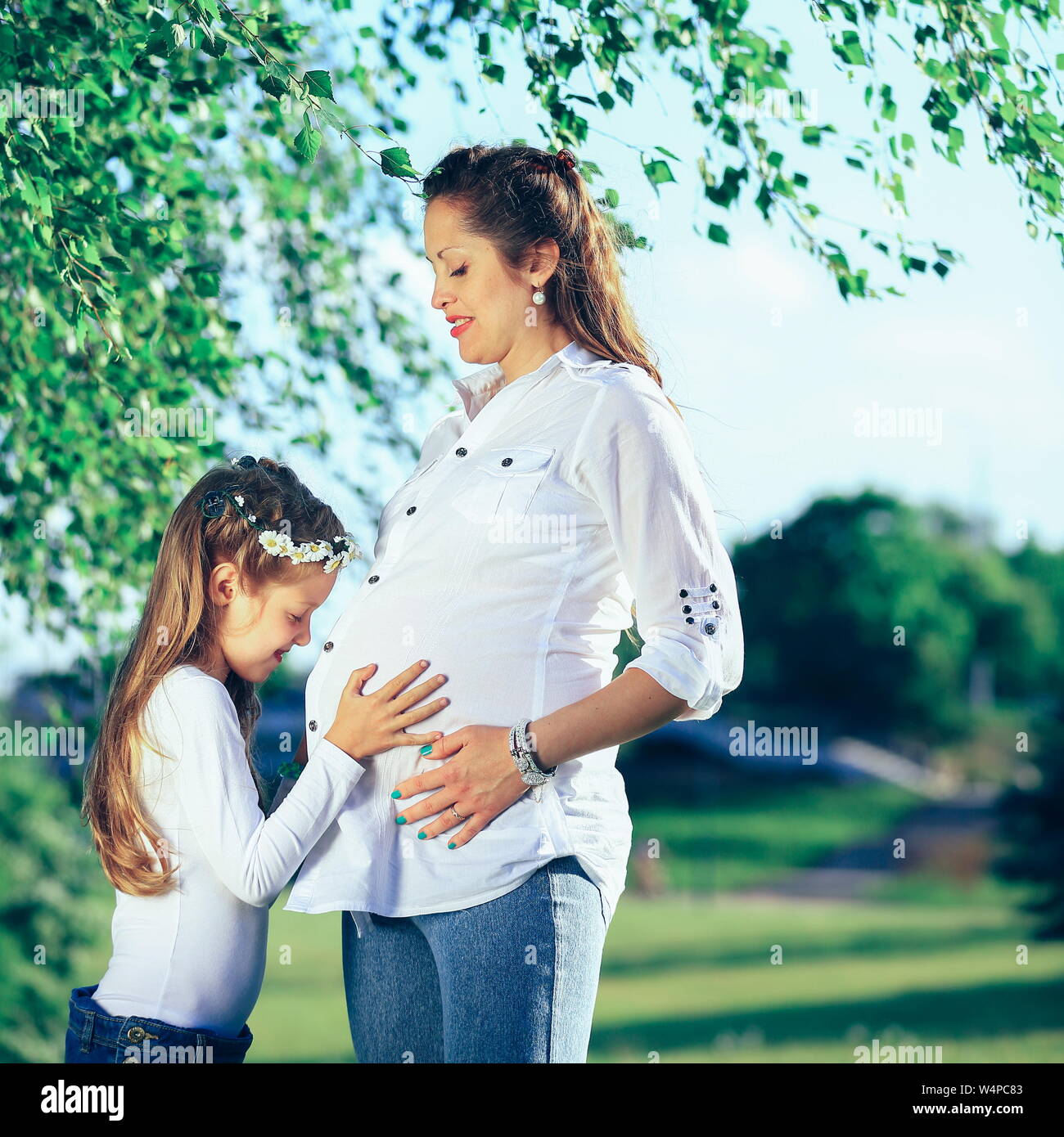 pregnant mother and little daughter on a walk in the Park on a Sunny ...