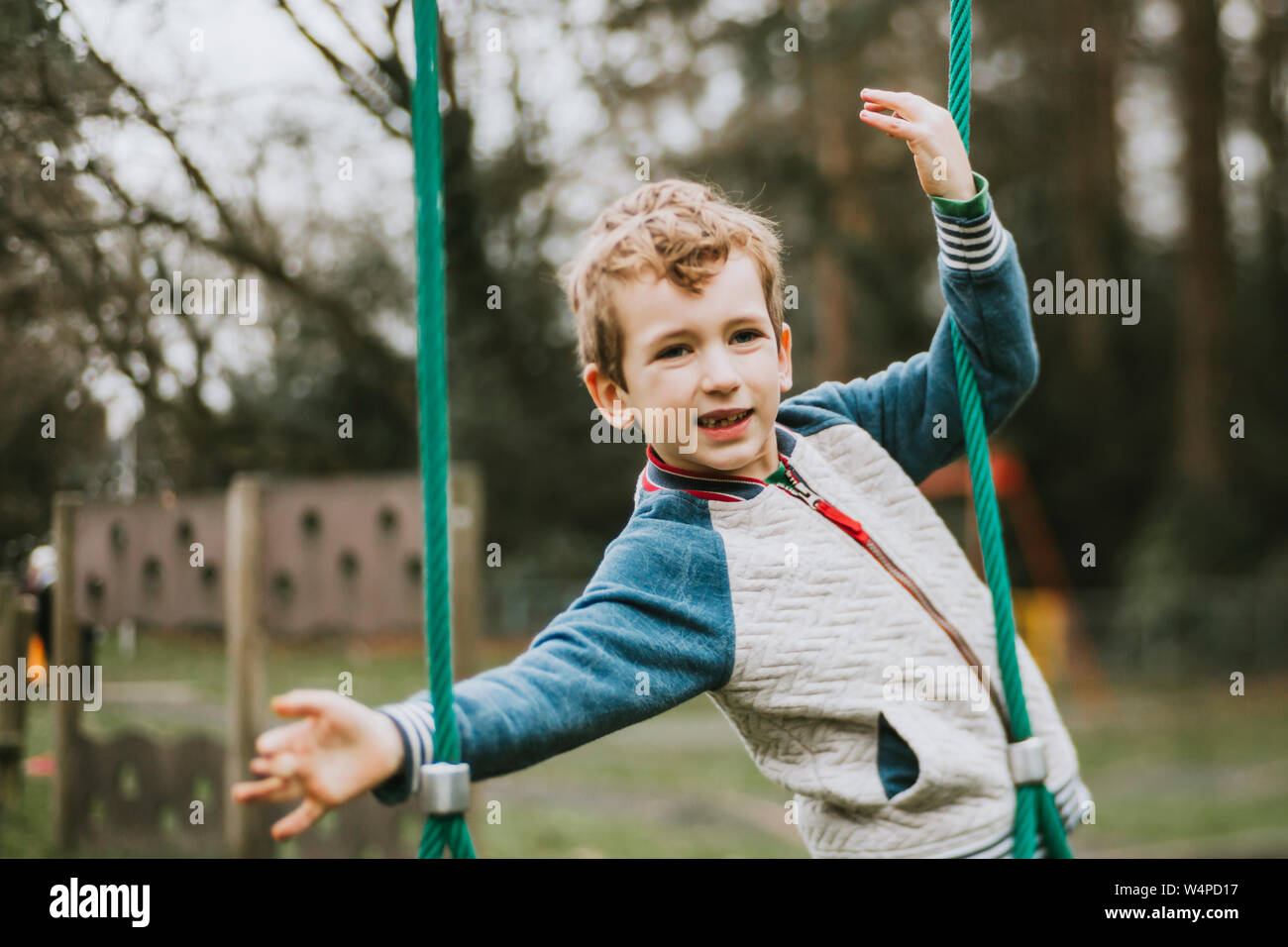 Portrait of boy balancing on jungle gym Stock Photo