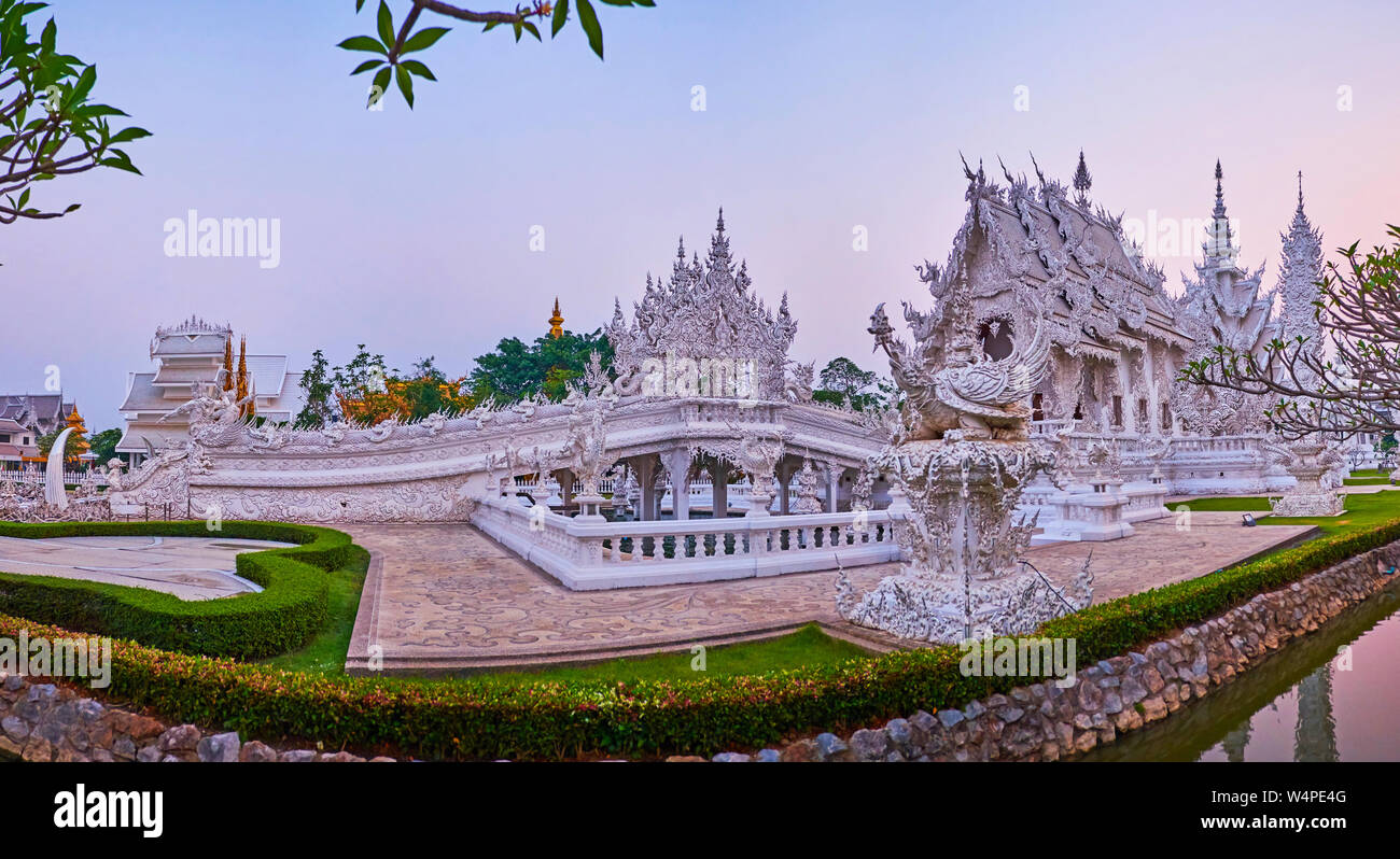 The evening walk in garden of White Temple with a view on its unusual ...