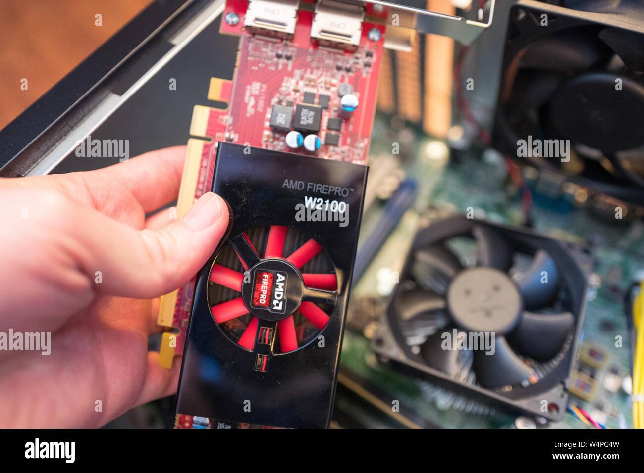Hand of a man installing an AMD Firepro Graphical Processing Unit (GPU), aka graphics card, in a cryptocurrency mining computer for mining the Bitcoin alternative Monero, San Ramon, California, August 29, 2018. () Stock Photo