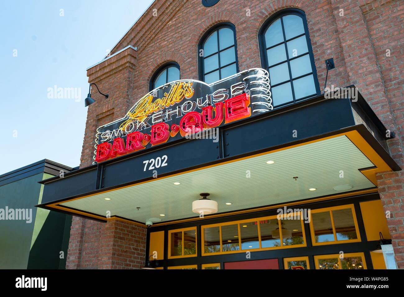 Neon lighted sign on brick facade at new Lucille's Barbecue restaurant