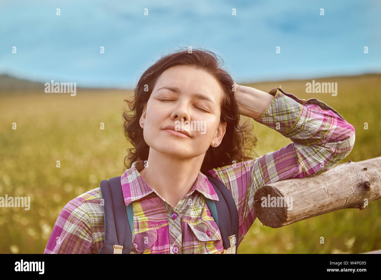 One woman turned to the sun with her eyes closed. Stock Photo
