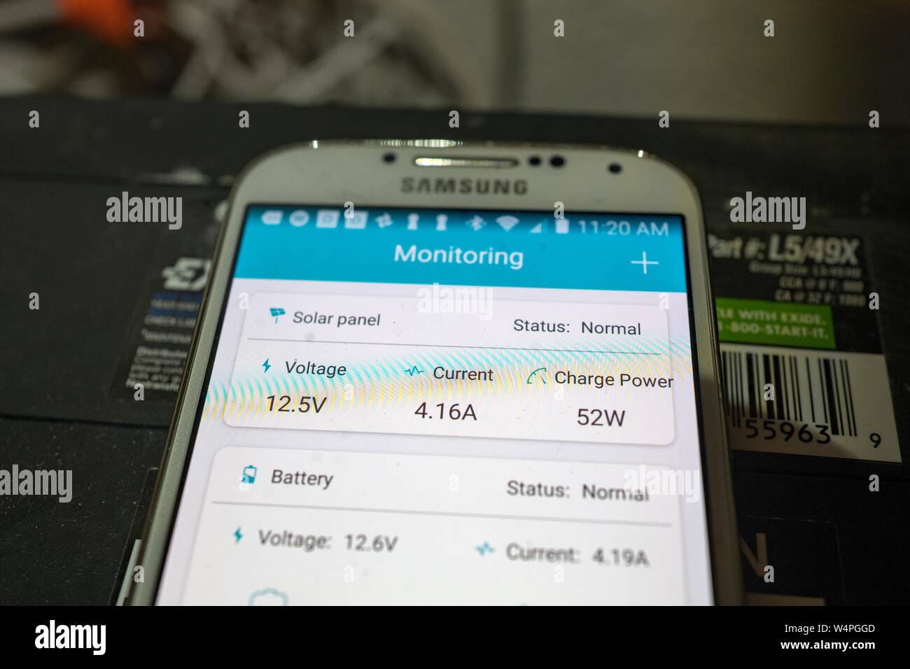 Close-up of Samsung smartphone with solar array monitoring app from solar company Renogy, placed on top of a battery bank and being used to monitor the performance of an off-grid residential solar array in San Ramon, California, September 10, 2018. () Stock Photo