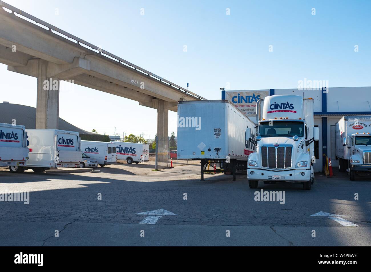 Delivery vehicles and tractor trailers with logos are visible at local distribution center for Cintas uniform delivery service in San Leandro, California, September 10, 2018. () Stock Photo
