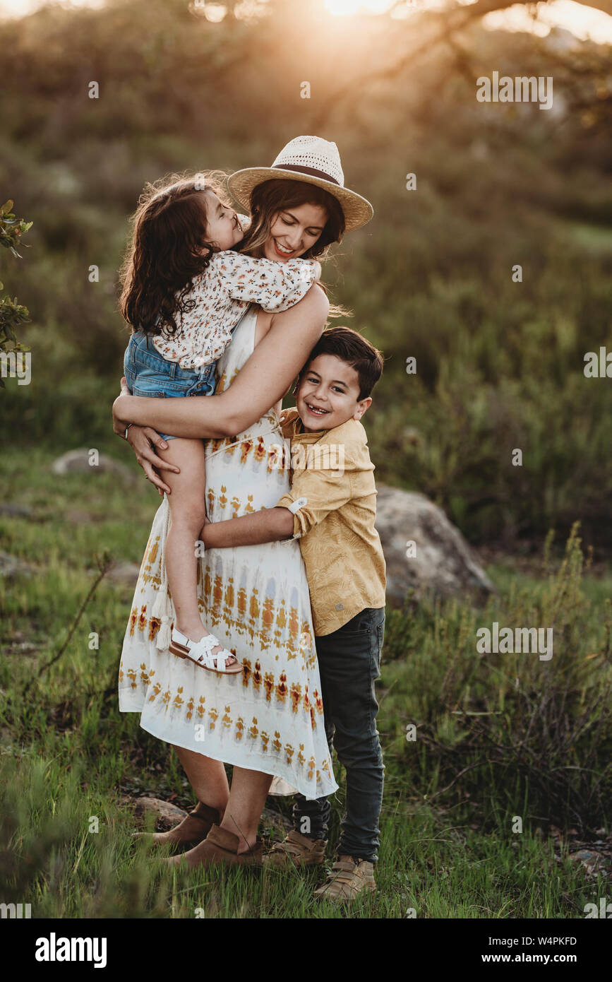 Full length view of mother and children in sunny field Stock Photo
