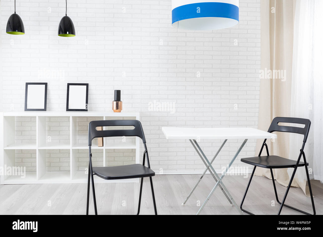 Clean modern interior with empty bookcase, table and two chairs Stock