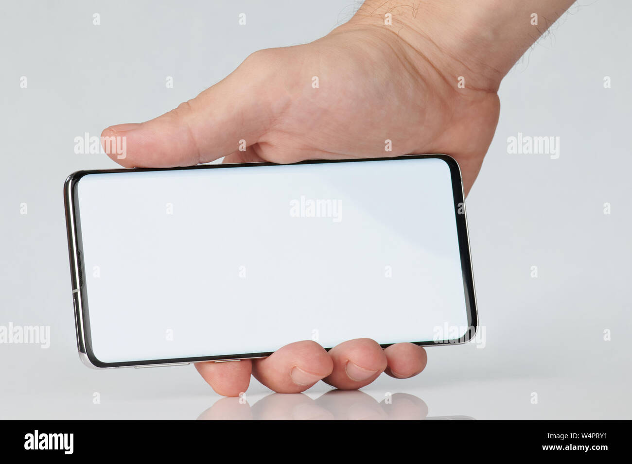 Close up of smartphone in hand on horizontal position isolated Stock Photo