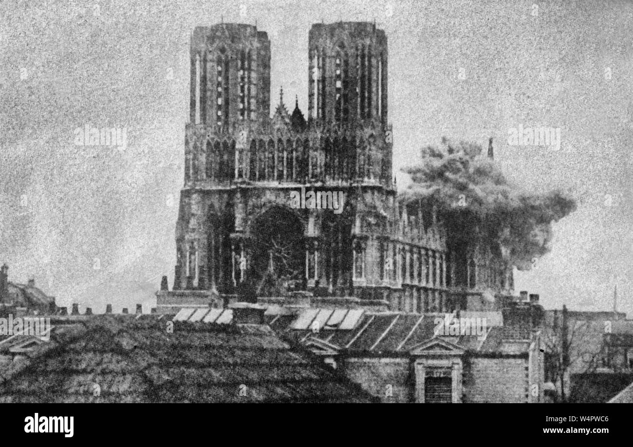 'The Cathedral of Notre Dame at Rheims was one of the most beautiful buildings in the world. The framework was still standing when the Germans began their drive in 1918. In this instance shells burst on the cathedral before the eyes of many spectators.' 20 September 1914 Stock Photo