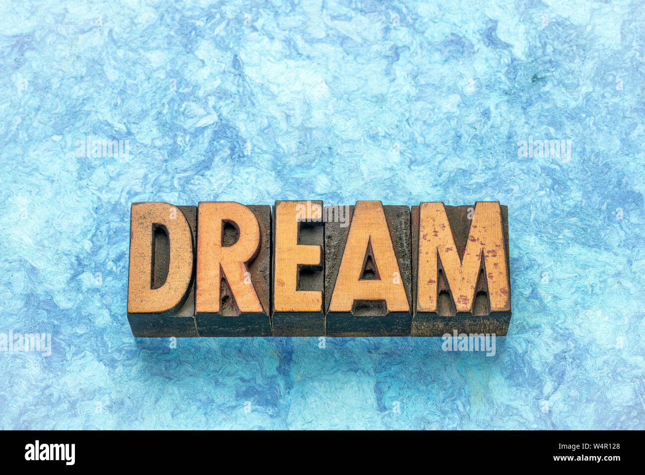 dream word in vintage letterpress wood type against blue bark paper Stock Photo