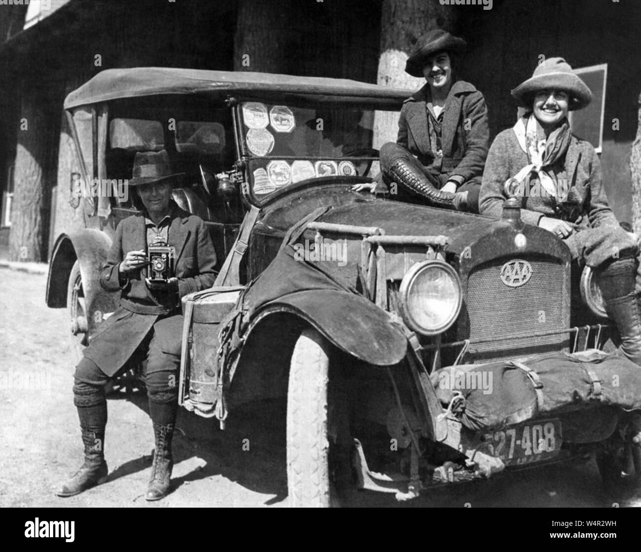 Author and photographer Mary Crehore Bedell (1870-1936) with traveling companions at Yellowstone National Park in 1922. Their vehicle bears a number of park stickers on the windshield along with a AAA Motor Club emblem on the grill. Bedell wrote the book, 'Modern Gypsies: The Story of a Twelve Thousand Mile Motor Camping Trip Encircling the United States' which was published in 1924. Stock Photo